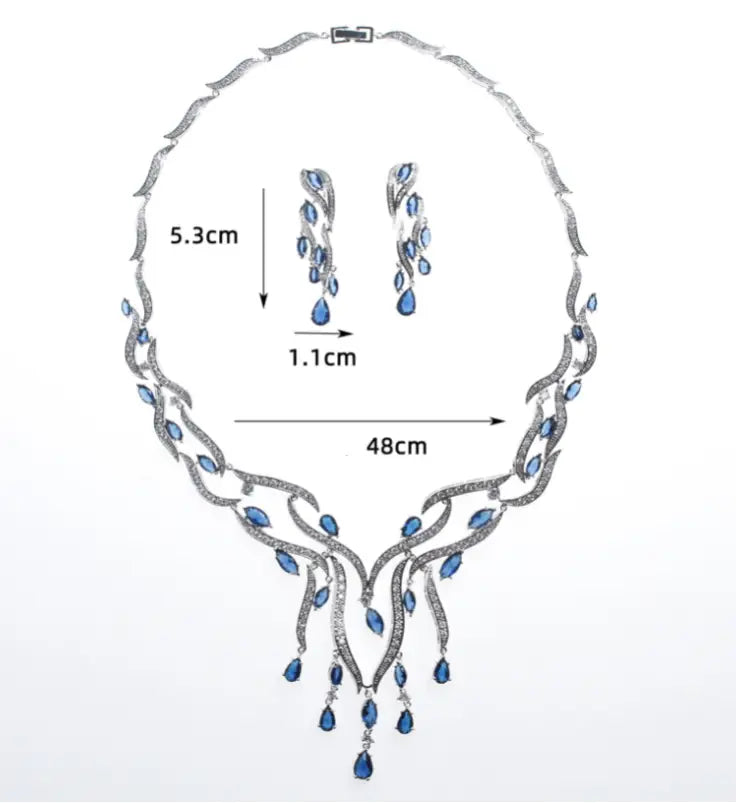 Elegant silver necklace with flowing leaf design adorned with blue teardrop-shaped stones and sparkling diamonds from an emerald green crystal jewelry zircon jewelry set.