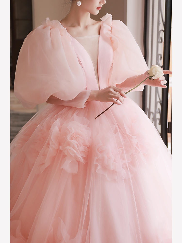a delicate blush pink high end banquet style host gown made of tulle featuring voluminous puffed sleeves and a layered ruffled skirt