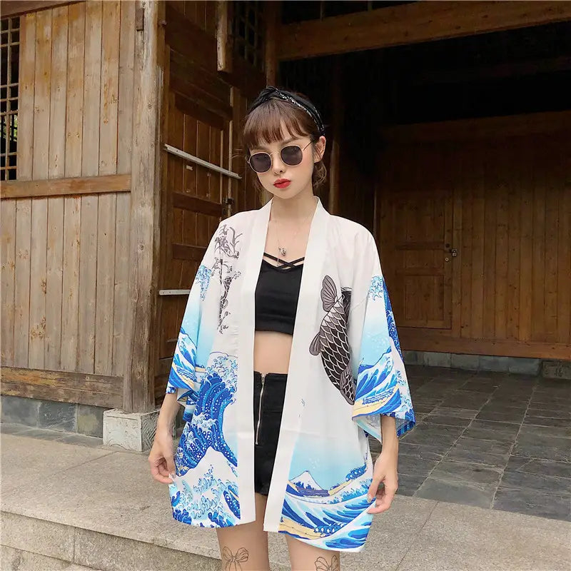 White kimono-style jacket with vibrant blue wave and fish prints inspired by Hokusai the great wave designed as sun protection clothing for outdoor use.
