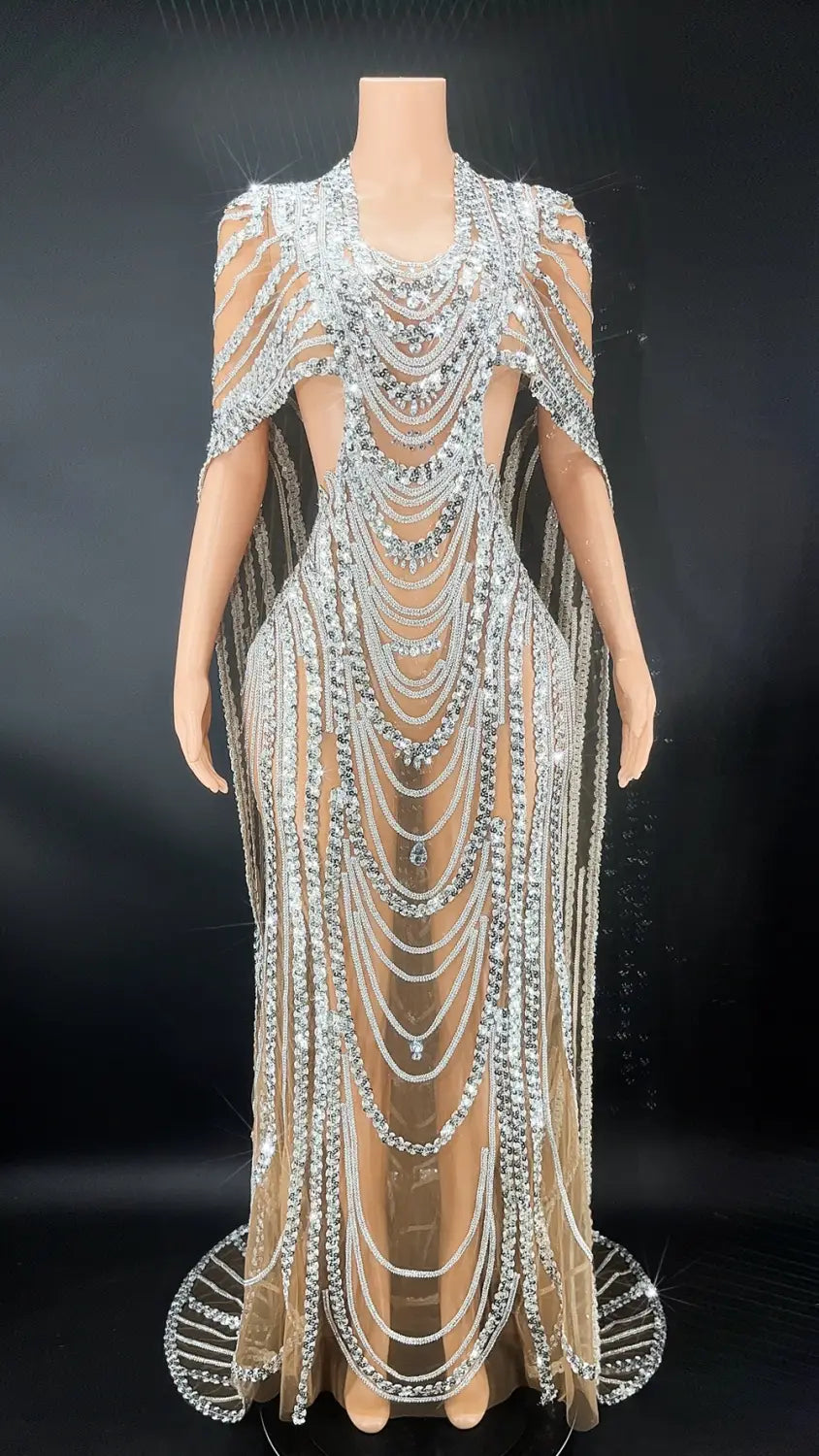 a shimmering silver beaded celebrate crystal sequin evening gown featuring cascading chains and sheer mesh fabric