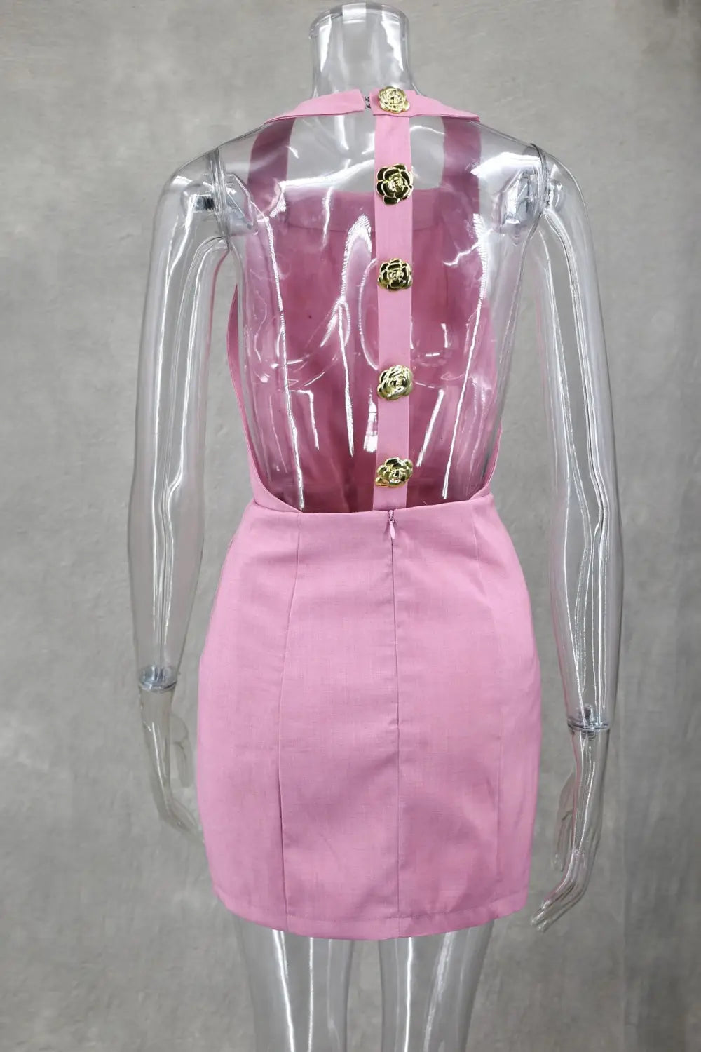 Pink satin mini backless dress with transparent back panel and gold tone rose button design
