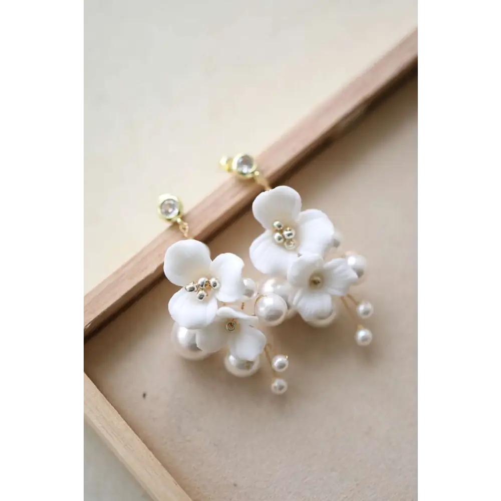 Delicate white ceramic flower pearl embellished bridal hairpin with handcrafted petals and gold toned studs