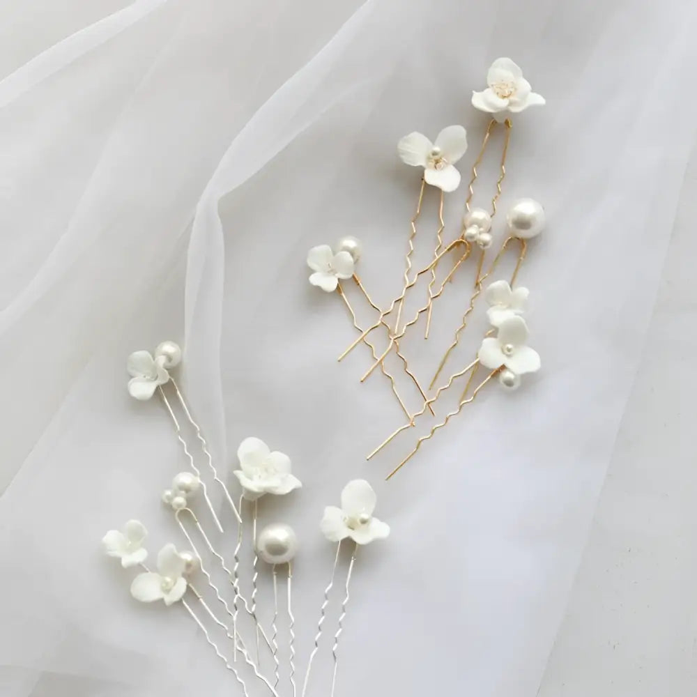 Delicate white ceramic flower pearl embellished bridal hairpin with gold and silver-toned metal bases and tiny pearls