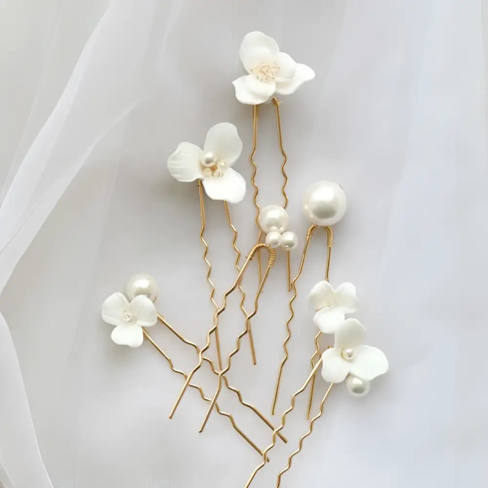 Elegant white ceramic flower pearl embellished bridal hairpin with gold-toned wire and delicate pearl accents