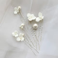 Elegant white floral embellished bridal hairpin featuring delicate white ceramic flowers and pearl embellishments
