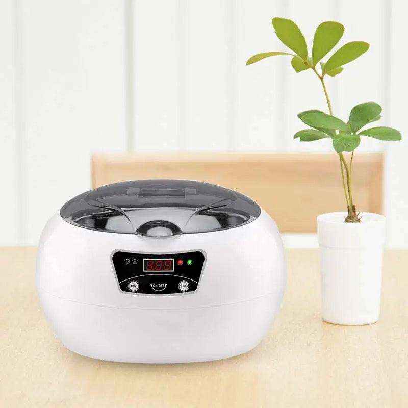 White oval-shaped ceramic ultrasonic cleaning machine with black lid and digital display for precise cleaning