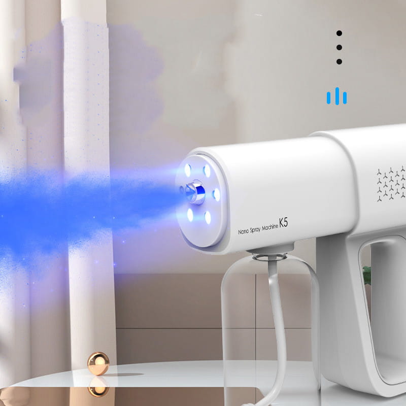 white handheld k5 pro electric sanitizer sprayer nano disinfection gun emitting blue mist as a spray gun for effective sanitization