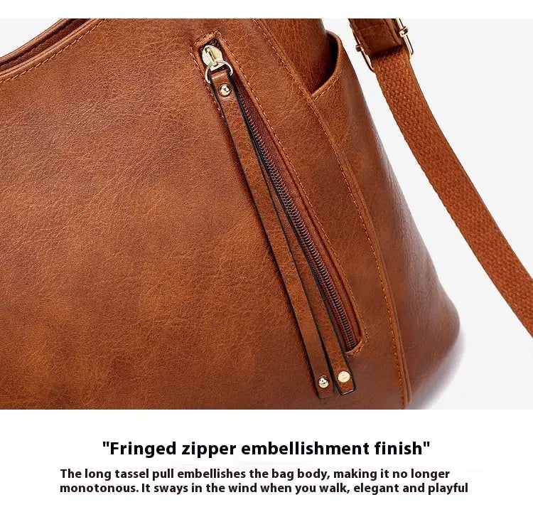 Brown faux leather large capacity luxury women leather hobo bag with fringed zipper pull and gold tone hardware.