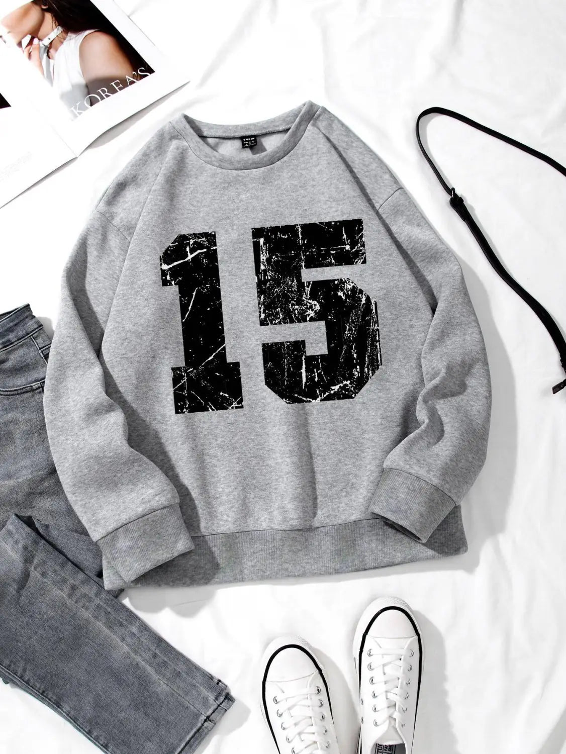 Gray crew neck sweatshirt featuring a large black marble-textured number 15 printed across the chest.