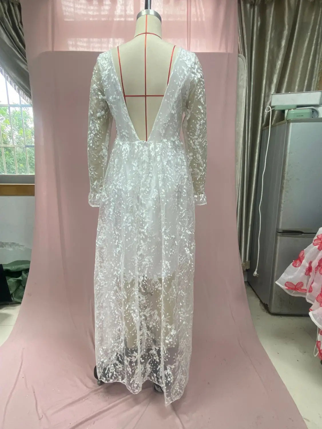 a delicate white long sleeve wedding dress lace gown with a deep v-back displayed on a mannequin showing the back side of the dress lace long design