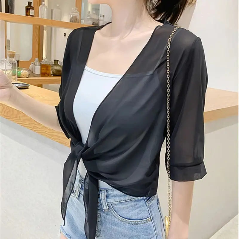 black sheer wrap top with three-quarter sleeves and tied front detail complementing a blue chiffon short shawl summer coat ideal for light summer coat sun protection.
