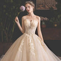 A strapless ivory champagne lace wedding gown with gold lace appliqués and voluminous tulle skirt for pregnant woman