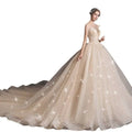A shimmering champagne lace wedding gown with intricate detailing and flowing train designed for a pregnant woman
