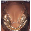 Champagne satin blouse paired with a shimmering gold mesh body chain featuring intricate rhinestone body jewelry embellishments