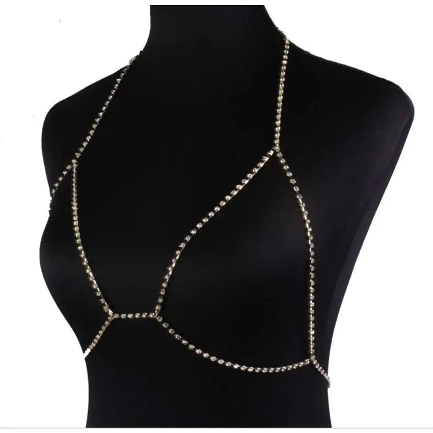A shimmering gold rhinestone body jewelry chain designed to drape elegantly over the champagne satin blouse