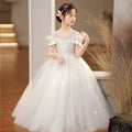 A white off-the-shoulder champagne sequined spandex princess dress with sparkling embellishments and girls tulle tutu