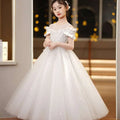 A white off-the-shoulder champagne sequined spandex princess dress with sparkling embellishments and girls tulle tutu