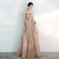 Strapless female wedding gown in champagne tulle toast with intricate gold embroidery and layered floor-length design