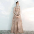 Strapless female wedding gown in blush with intricate gold embroidery and champagne tulle toast layered detailing