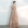 A strapless female wedding gown in champagne tulle toast with intricate gold embroidery and layered tulle fabric