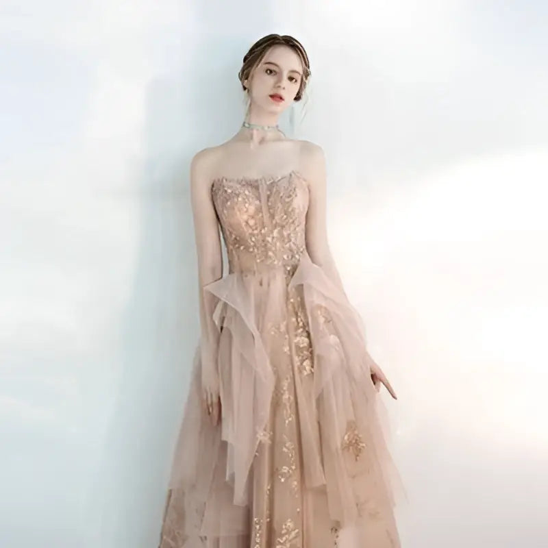 Champagne tulle toast female wedding gown featuring a strapless floor-length design with intricate gold embroidery and layered tulle fabric