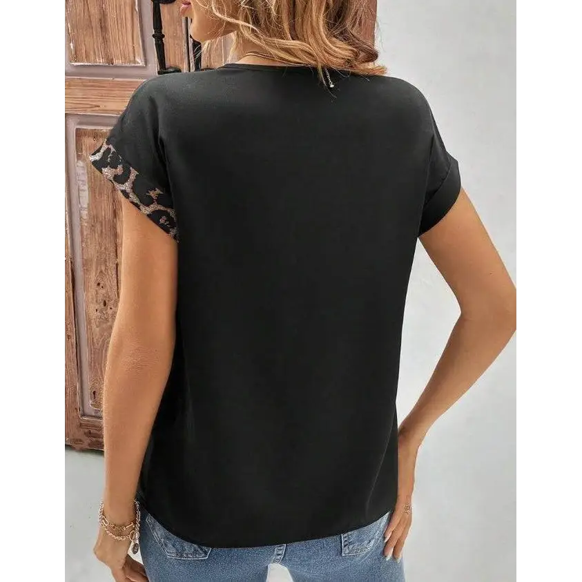 Chemise pour femmes noire à manches chauve-souris avec poignets léopard et boutons dorés élégants