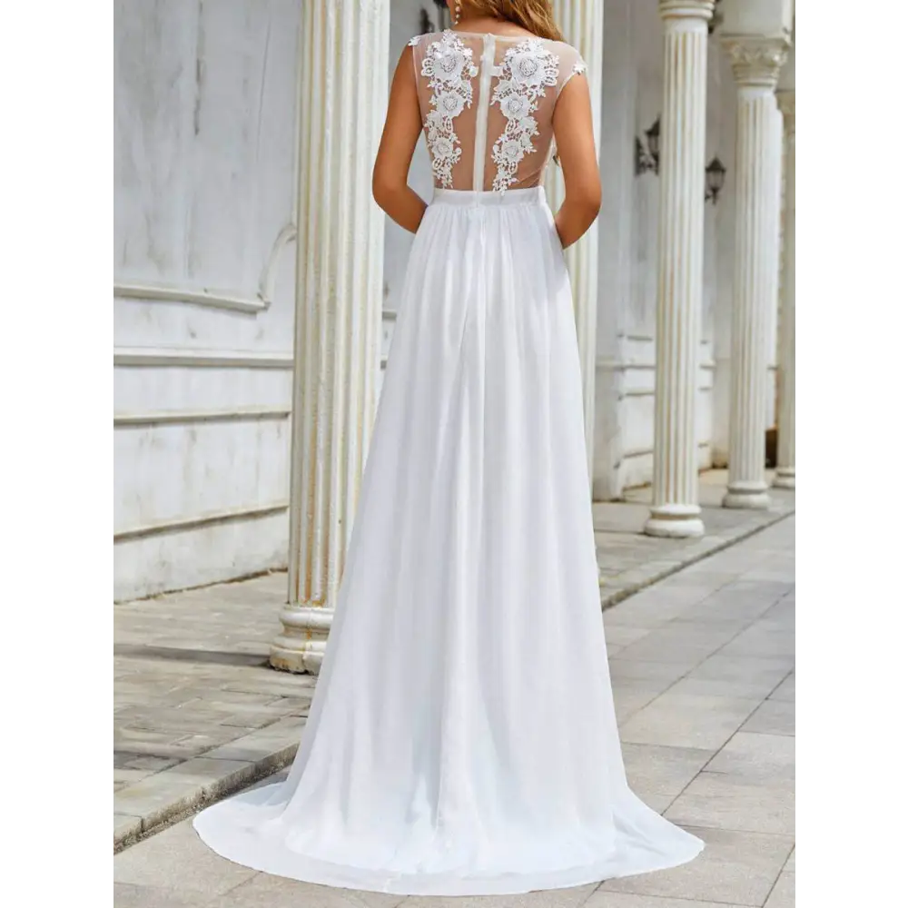 Back view of a flowing white chiffon lace trailing wedding large swing dress with intricate lace and sheer mesh panel