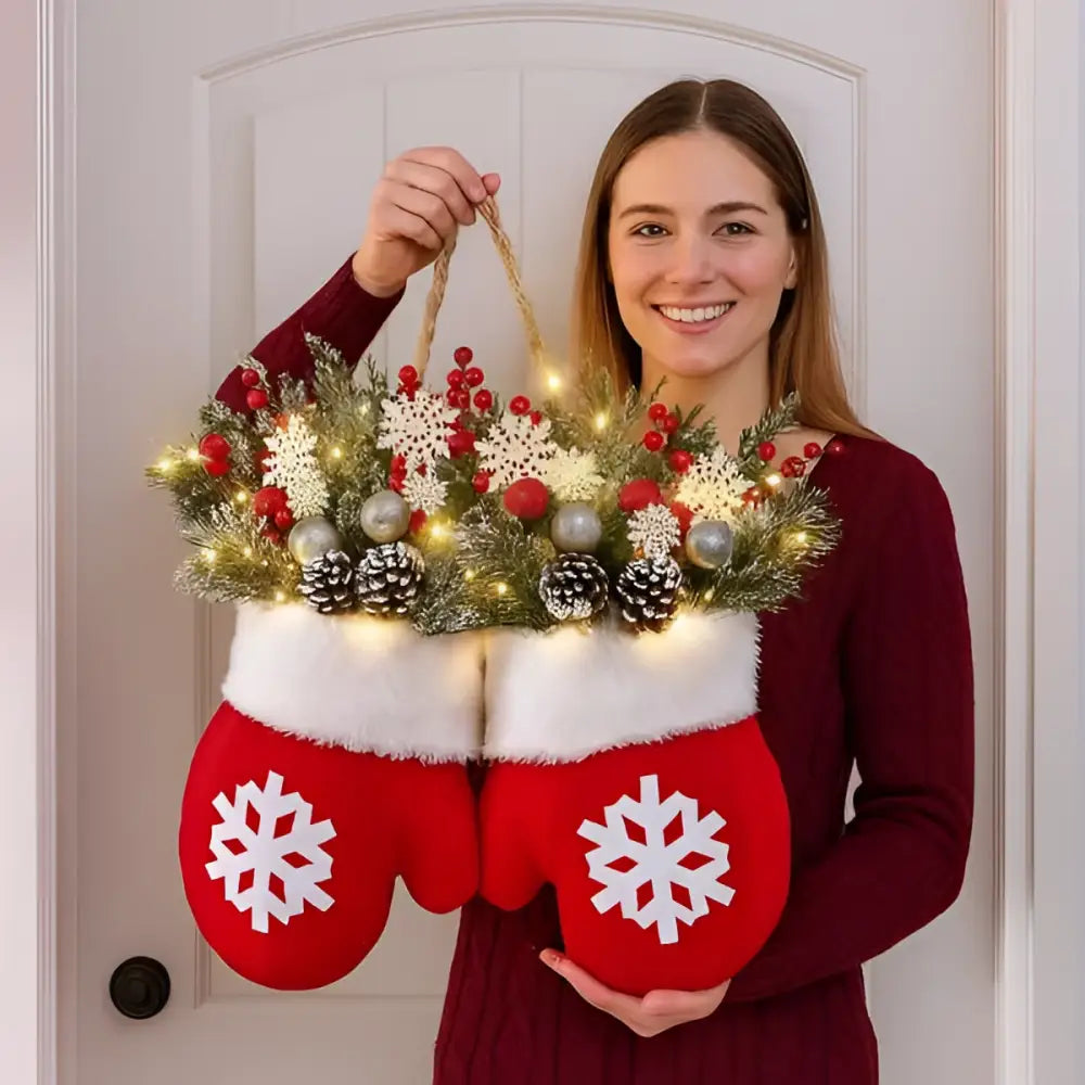 Red christmas garland creative glove shaped wreath with festive greenery, snowflakes, red berries, pinecones, and string lights