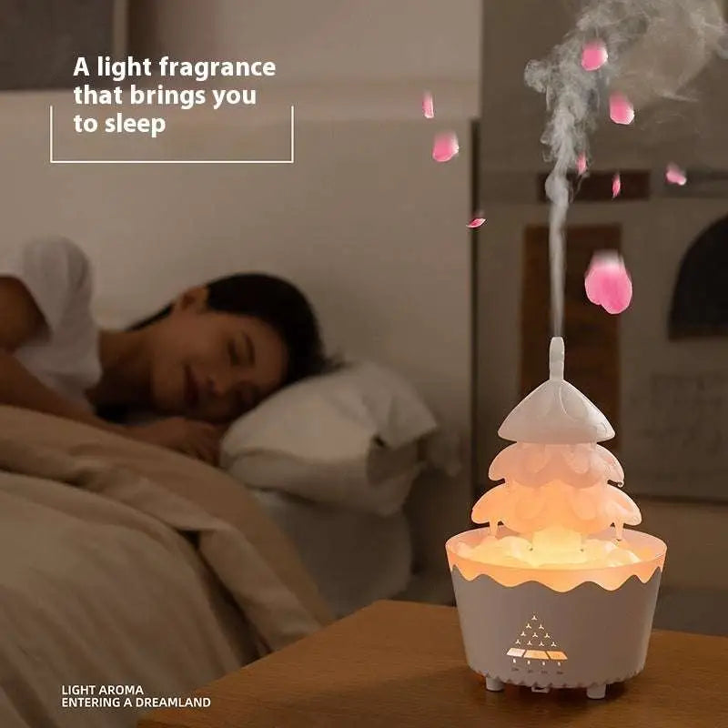 A festive christmas tree essential oil aroma diffuser humidifier with a soft gray base and warm orange glow