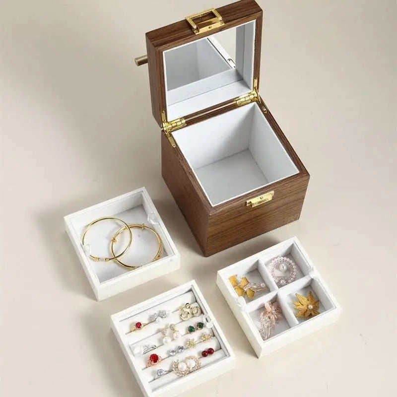 Classical wooden jewelry box with gold-tone latch, interior mirror, and white velvet-lined compartments holding earrings