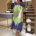 A flowing tie-dye maxi dress with round neck loose fit and loose short sleeves in shades of green and purple color block