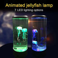 Transparent cylindrical jellyfish lamp with color changing led jellyfish glowing in green and blue hues for night light use