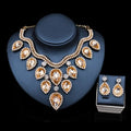 Gold-toned colorful exaggerated bride necklace and earring set with cascading amber crystals and clear rhinestones on dark bust