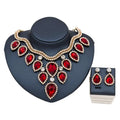 Colorful exaggerated bride necklace and earring set featuring red teardrop gemstones with gold tone and diamond accents