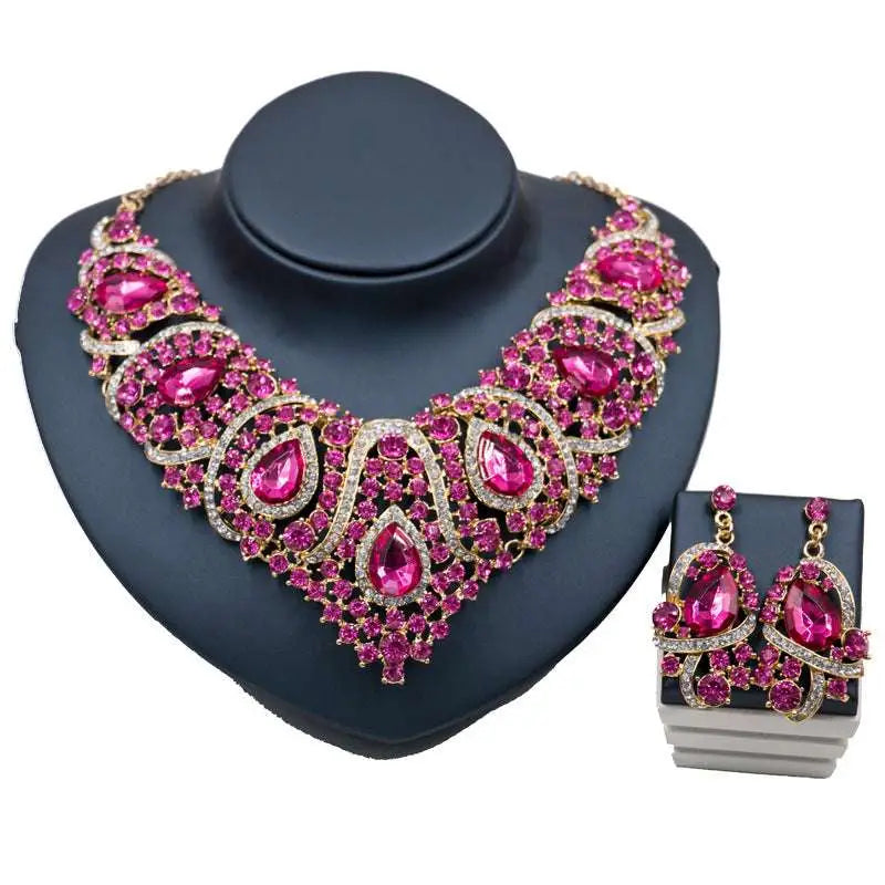 Colorful exaggerated bride statement necklace and earrings with fuchsia crystals and alloy color plating displayed on black bust