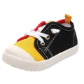 Black canvas colorful kindergarten indoor shoes with yellow toe cap, red and white laces, and rubber soles designed for toddlers