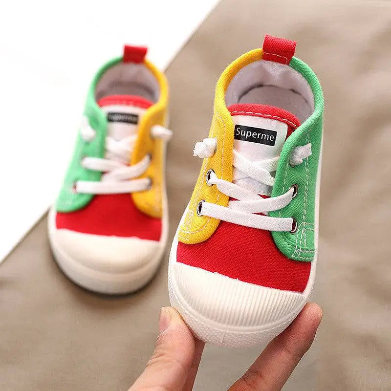 Colorful kindergarten indoor shoes with red yellow and green canvas panels and rubber soles designed for comfort
