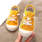 Bright yellow colorful kindergarten indoor shoes with white laces and rubber soles designed for indoor use