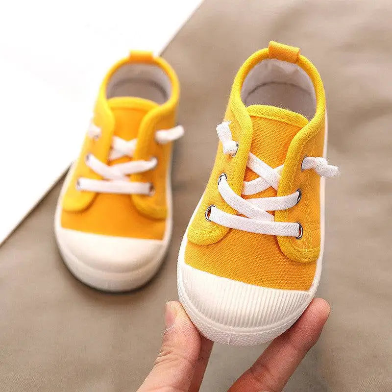 Bright yellow colorful kindergarten indoor shoes with white laces and rubber soles designed for indoor use