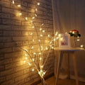A delicate colorful led snowflake branch decoration with warm white led snowflake lights in a natural tree pattern