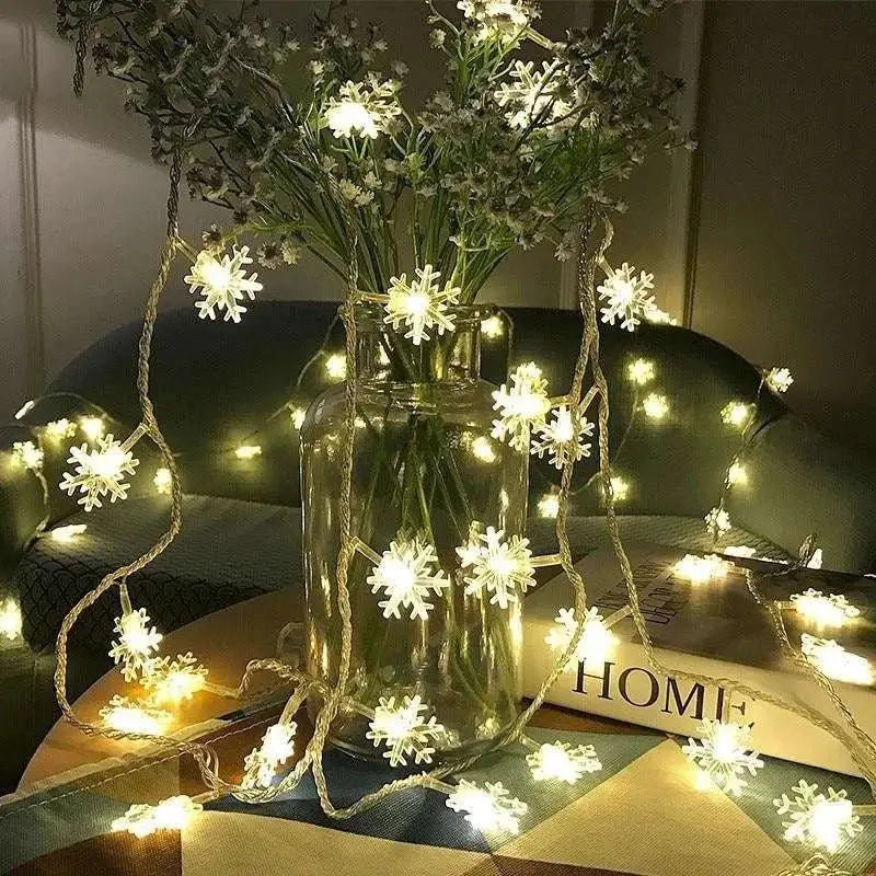 String of colorful led snowflake lights with warm white bulbs wrapped around a clear glass vase