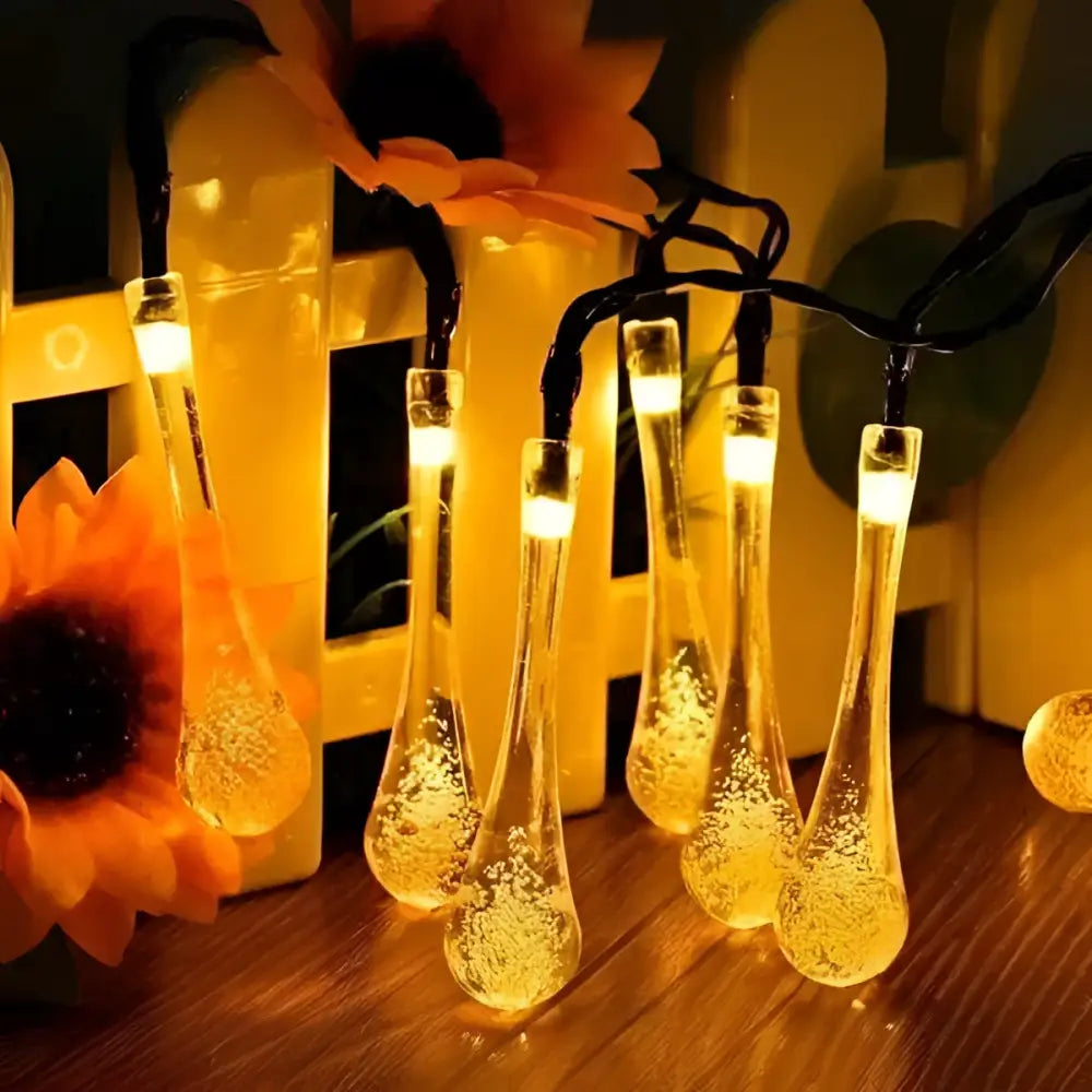 Warm amber-glowing colorful teardrop bubble garden solar lights with clear glass bodies and internal bubble effects