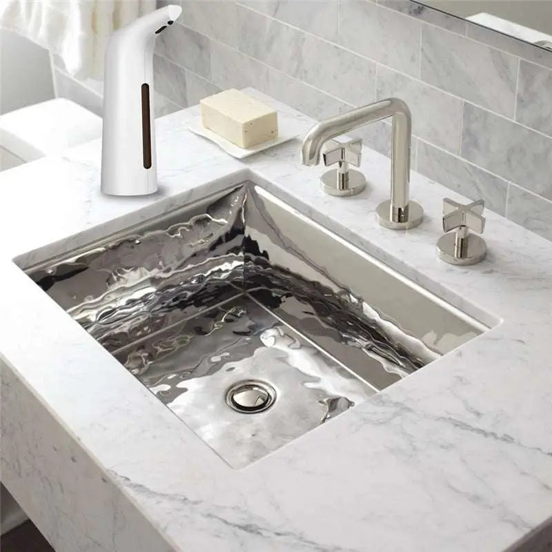 Shiny hammered stainless steel undermount sink with sleek modern contact-free automatic induction soap dispenser and brown accent
