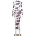 A form-fitting white midi dress with black floral patterns featuring irregular holes in a cow print women style