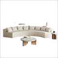 Cream corduroy curved sectional sofa in cream color with vertical ribbed texture and matching striped cushions