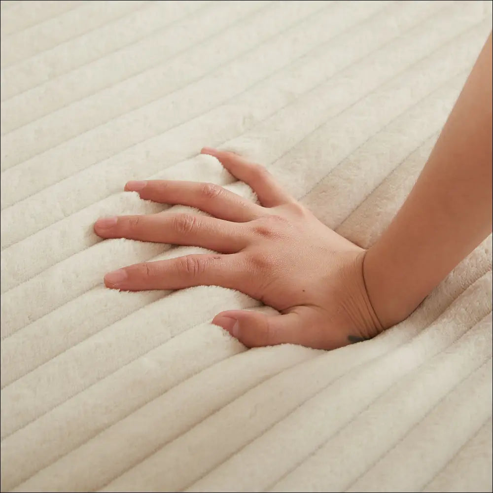 A hand rests on a cream corduroy round recliner neck pillow design with soft ribbed texture and plush material