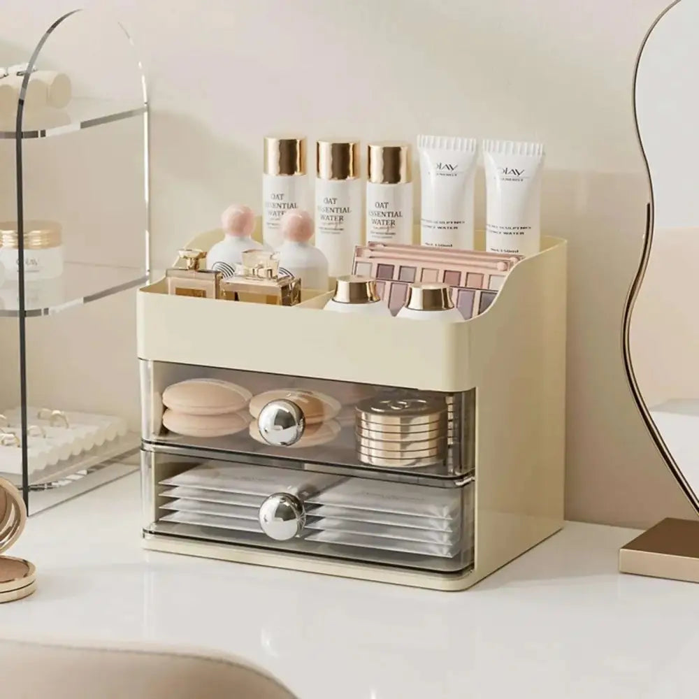 Cream countertop cosmetic two-drawer display case vanity with transparent front panels and silver knobs for storage