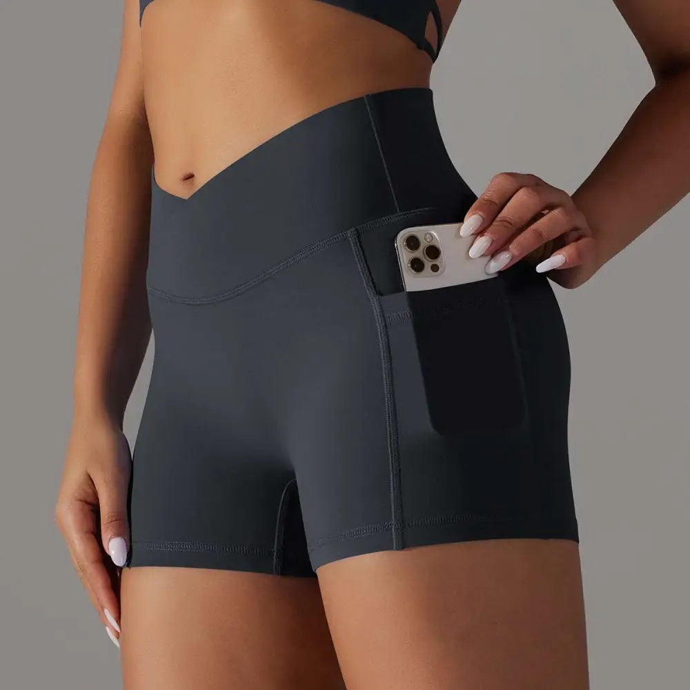 Dark gray high-waisted athletic shorts with pocket design fitness feature holding a smartphone for active use