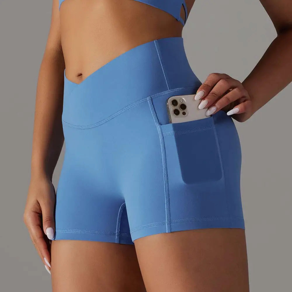 Light blue high-waisted athletic shorts with pocket design fitness feature holding a smartphone for active use