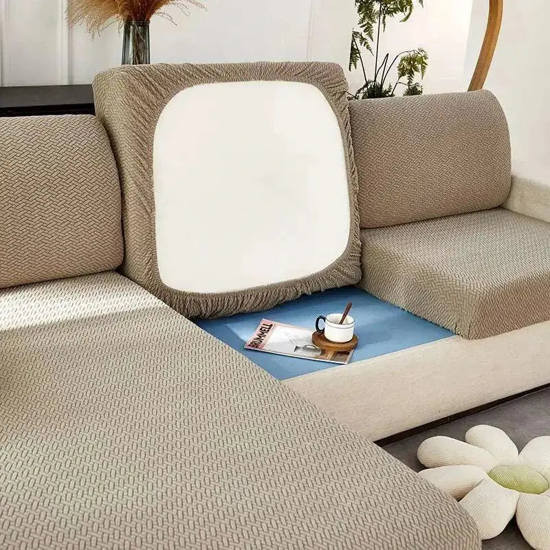 Cream stretchy universal sofa cover in beige textured fabric with white cushion insert for versatile protection